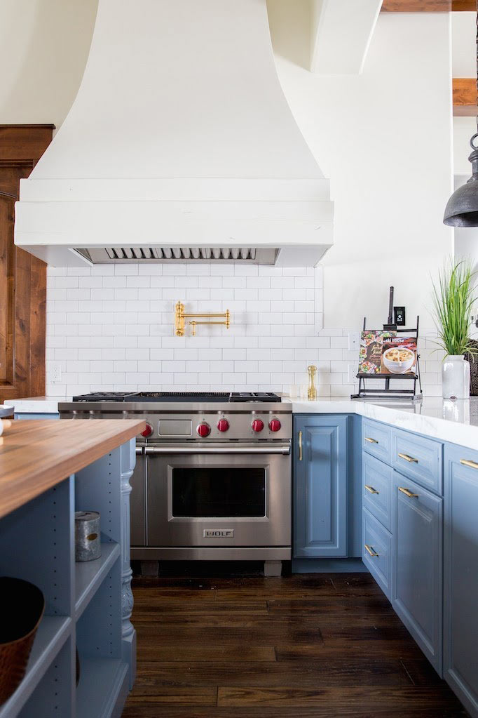 Brass Waterstone pot filler faucet mounted above a stainless steel range.
